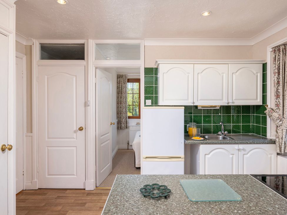 A kitchen with cabinets and a sink at The Hayloft Budock Water near Falmouth
