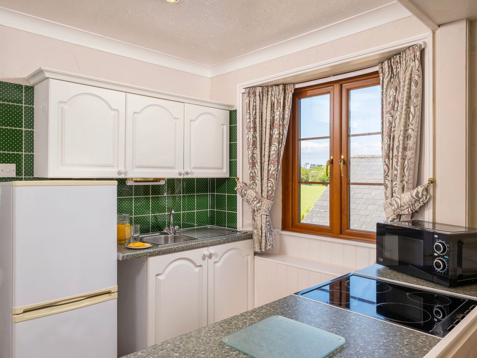 A kitchen with cabinets and appliances at The Hayloft Budock Water near Falmouth