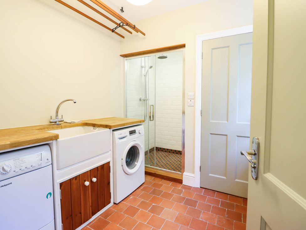 A utility room with a washing machine and a sink at Dolhiryd in Glyn Ceiriog, near Chirk