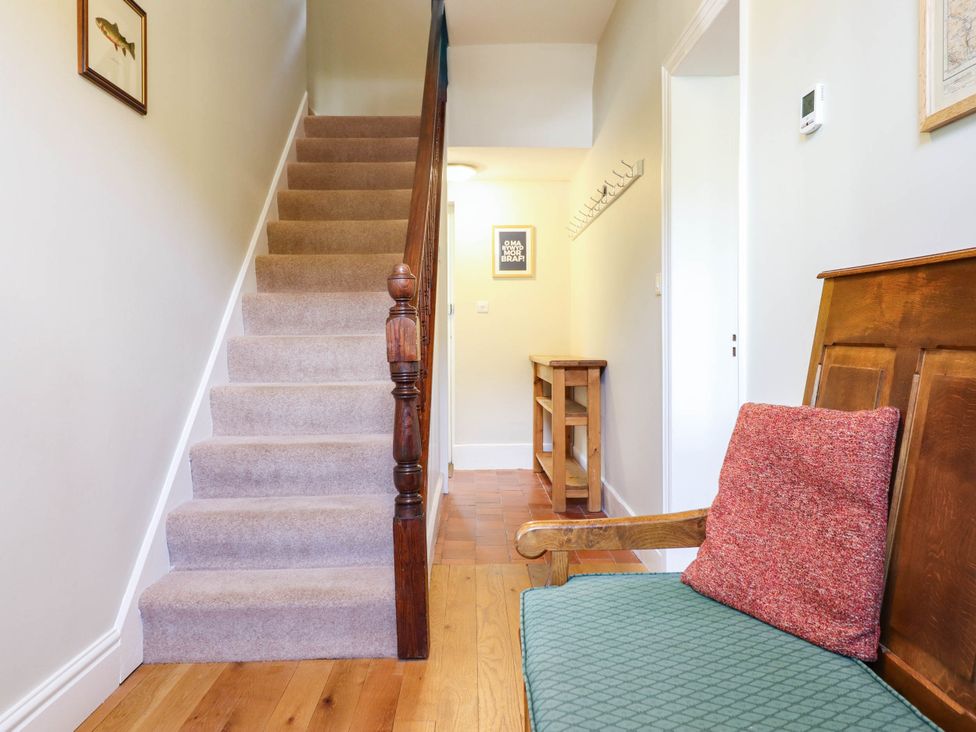 A hallway with a staircase and a bench at Dolhiryd, Glyn Ceiriog, near Chirk