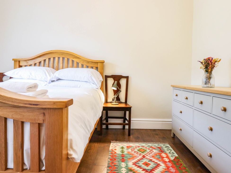 A bedroom with a bed and dresser at Dolhiryd in Glyn Ceiriog, near Chirk