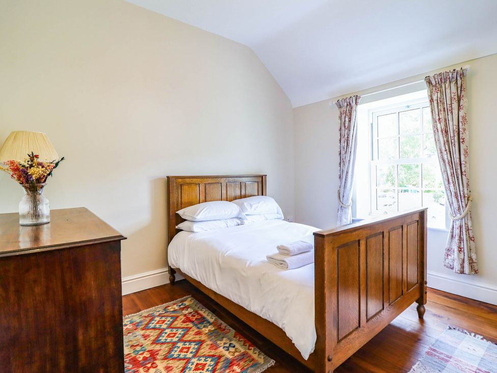 A bedroom with a bed and window at Dolhiryd, Glyn Ceiriog, near Chirk