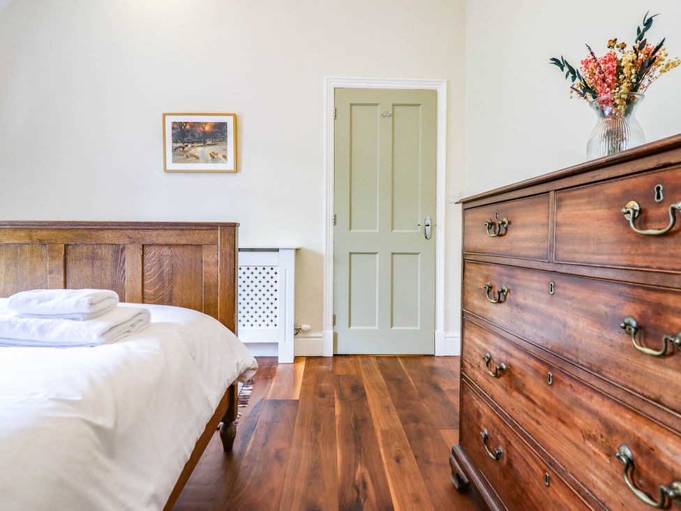 A bedroom with a bed and a chest of drawers at Dolhiryd, Glyn Ceiriog, near Chirk