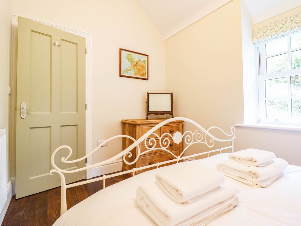 A bedroom with a bed and a wooden dresser at Dolhiryd in Glyn Ceiriog, near Chirk