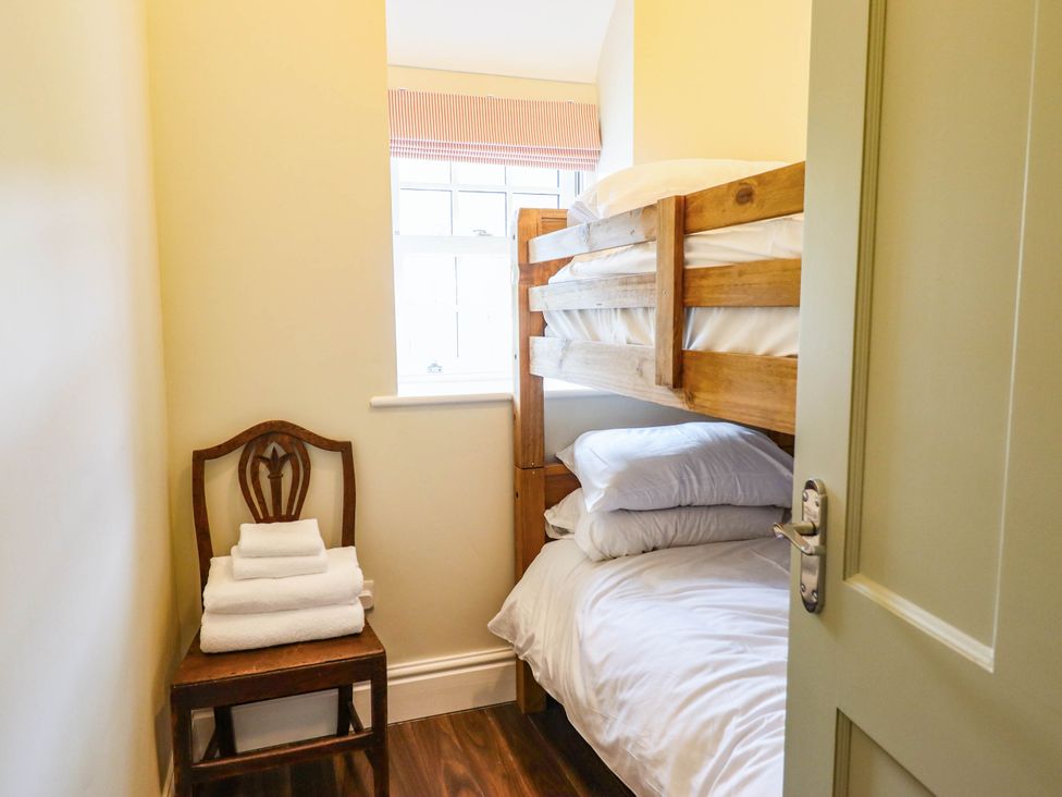 A bedroom with a bunk bed and a chair at Dolhiryd in Glyn Ceiriog near Chirk