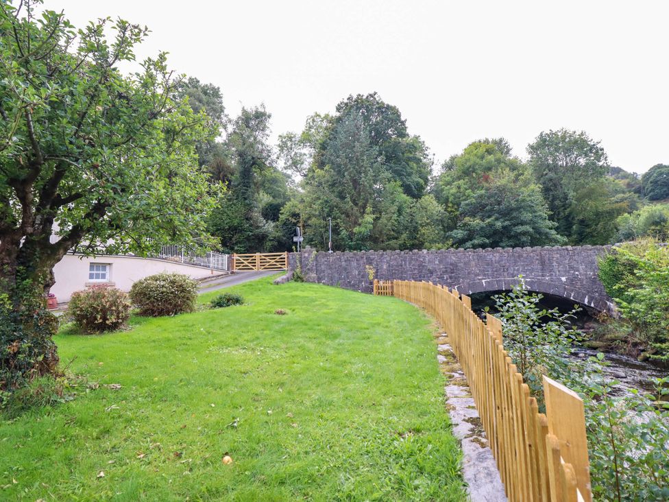 A garden with a bridge and stream at Dolhiryd in Glyn Ceiriog, near Chirk
