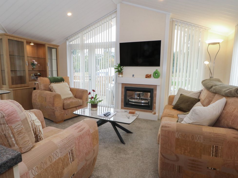 A living room with sofas and a television at Labernum in Lytham St. Annes