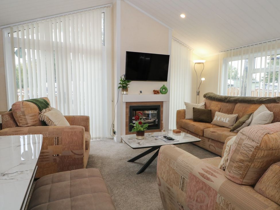 A living room with a television and two sofas at Labernum in Lytham St. Annes