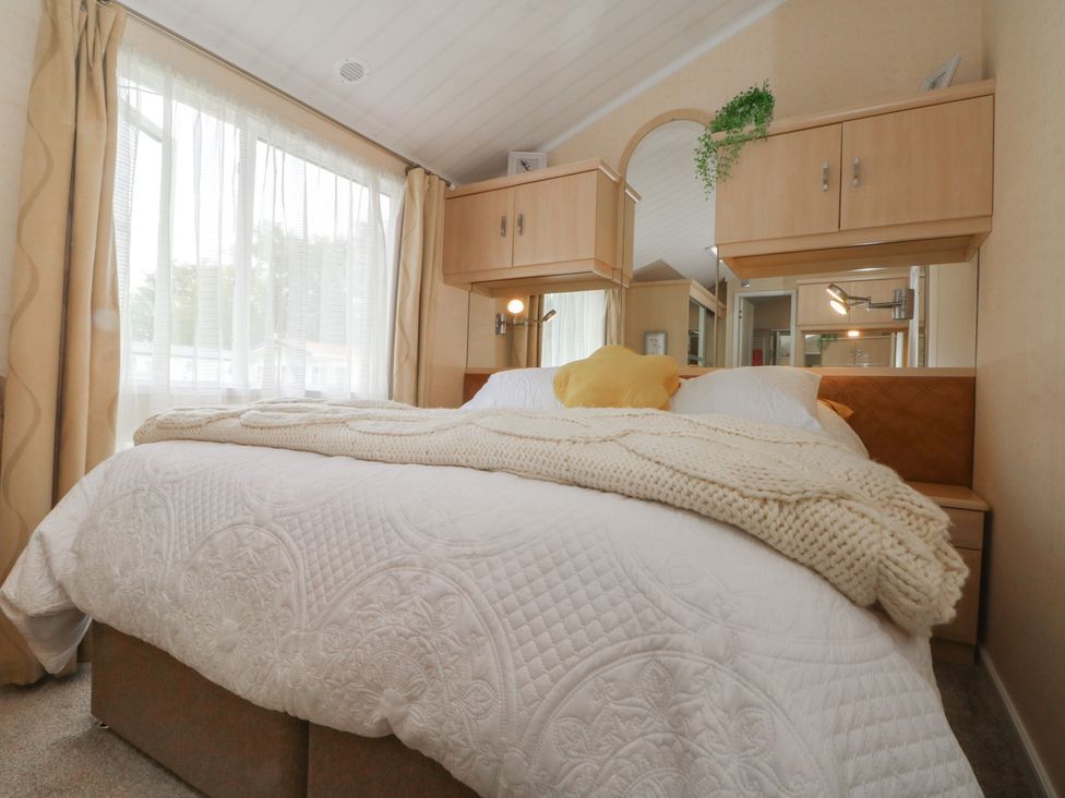 A bedroom with a bed and shelves at Labernum in Lytham St. Annes