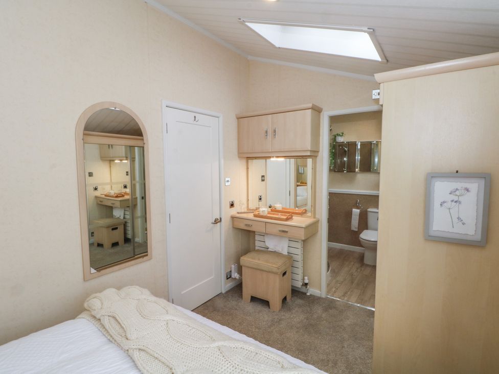 A bedroom with a dressing table and bathroom access at Labernum in Lytham St. Annes
