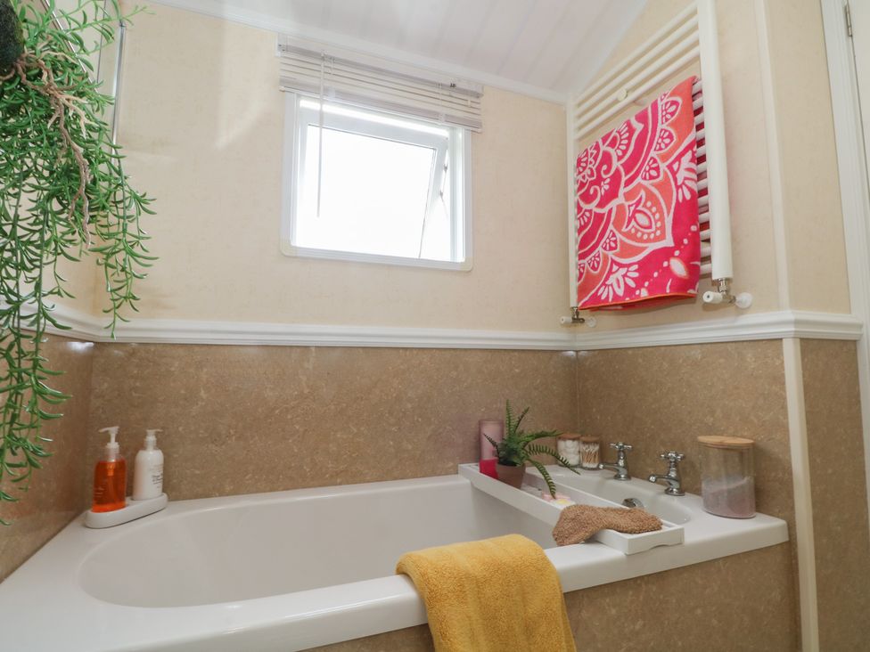 A bathroom with a bathtub and a window at Labernum Lytham St. Annes