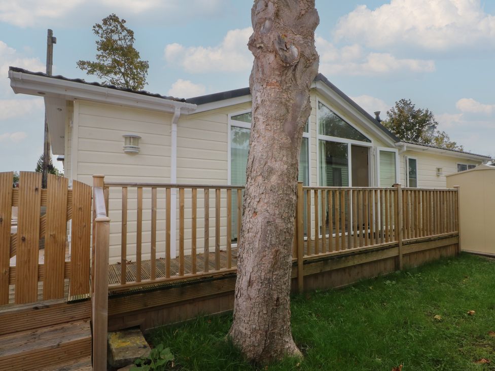 A holiday home exterior with decking and a tree at Labernum in Lytham St. Annes