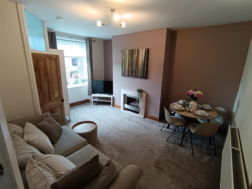 A living room with a sofa and dining table at 14 Lindon Street