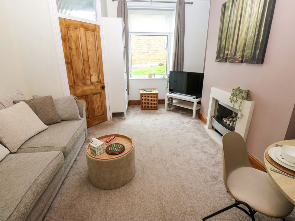 A living room with a sofa and a television at Steam View Cottage in Haworth