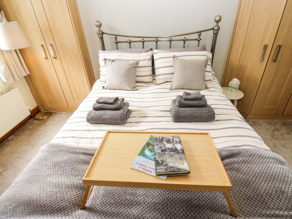 A bedroom with a bed and towels at Steam View Cottage in Haworth