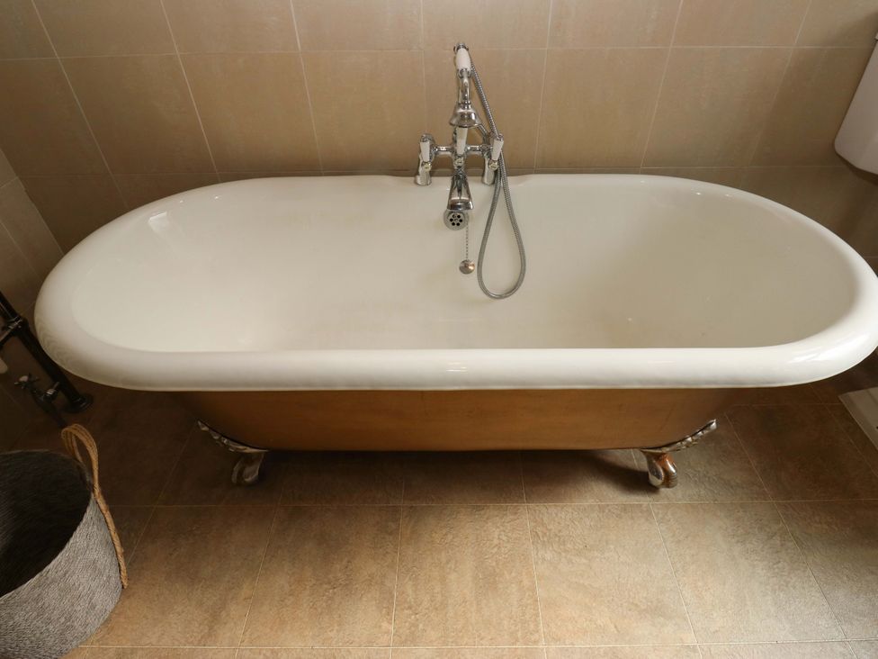 A bathtub with faucet in a bathroom at Steam View Cottage, Haworth