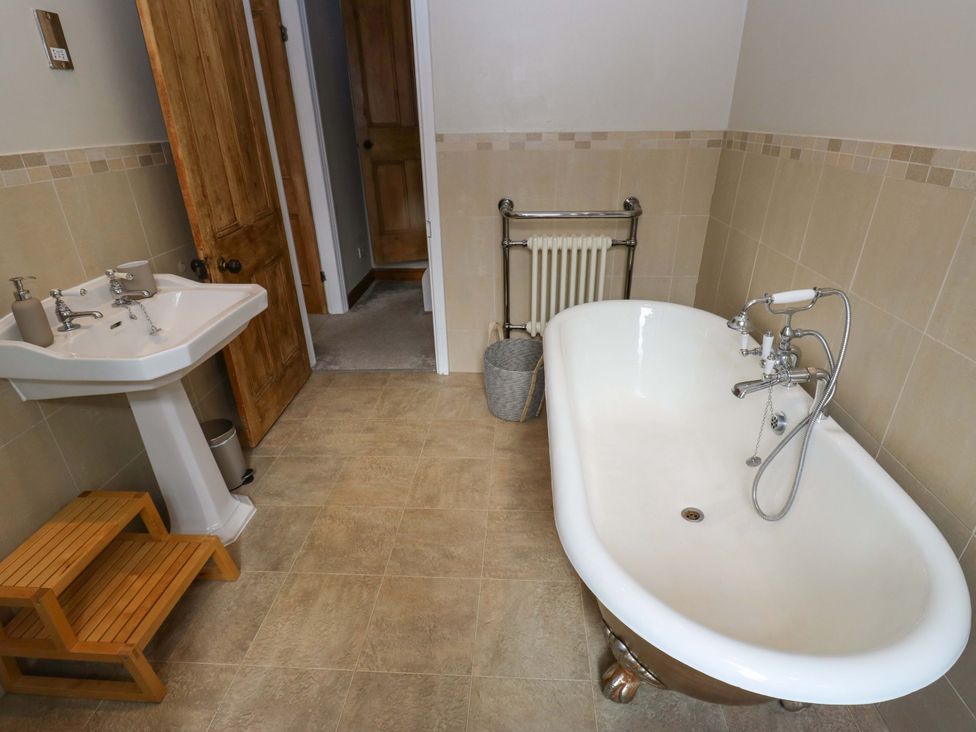 A bathroom featuring a bathtub and sink at Steam View Cottage in Haworth