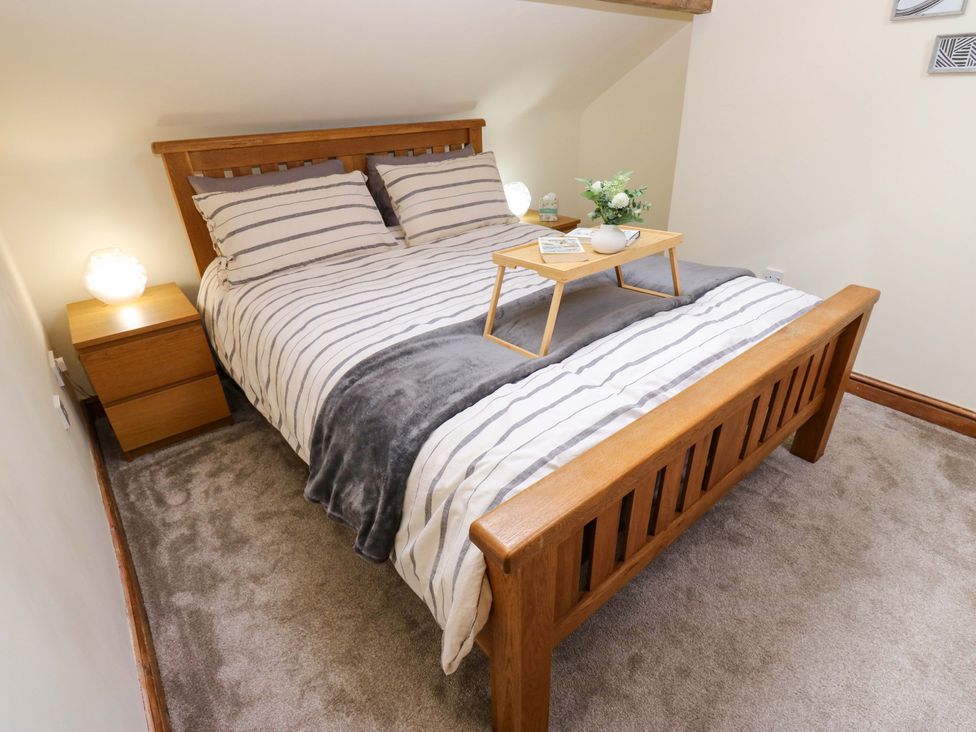 A bedroom with a bed and bedside table at Steam View Cottage in Haworth