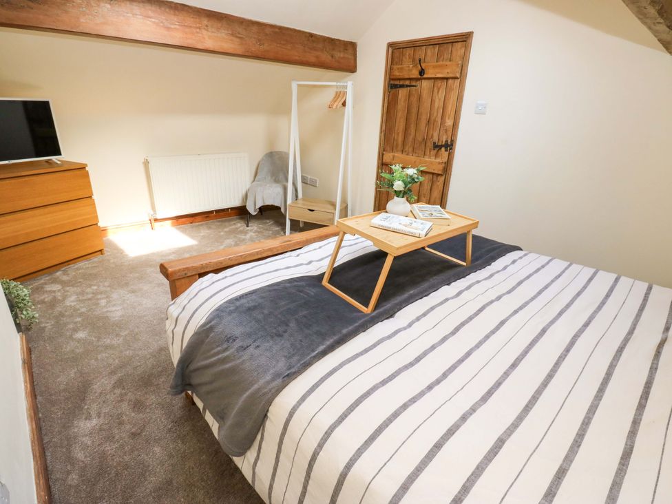 A bedroom with a bed and television at Steam View Cottage, Haworth