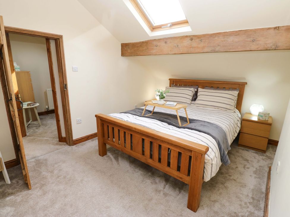 A bedroom with a bed and bedside table at Steam View Cottage in Haworth