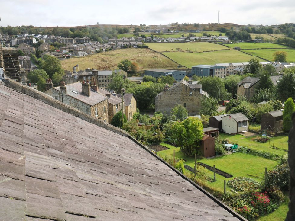 A view of houses and gardens from a rooftop at Steam View Cottage in Haworth