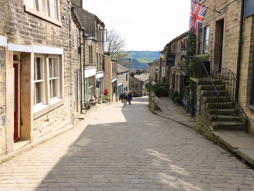 A street view with cobblestones and buildings at Steam View Cottage in Haworth