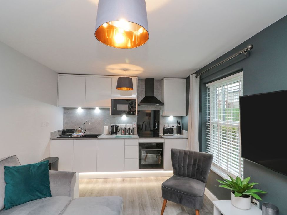 A kitchen with a sofa and appliances at Rosie's Retreat in Filey