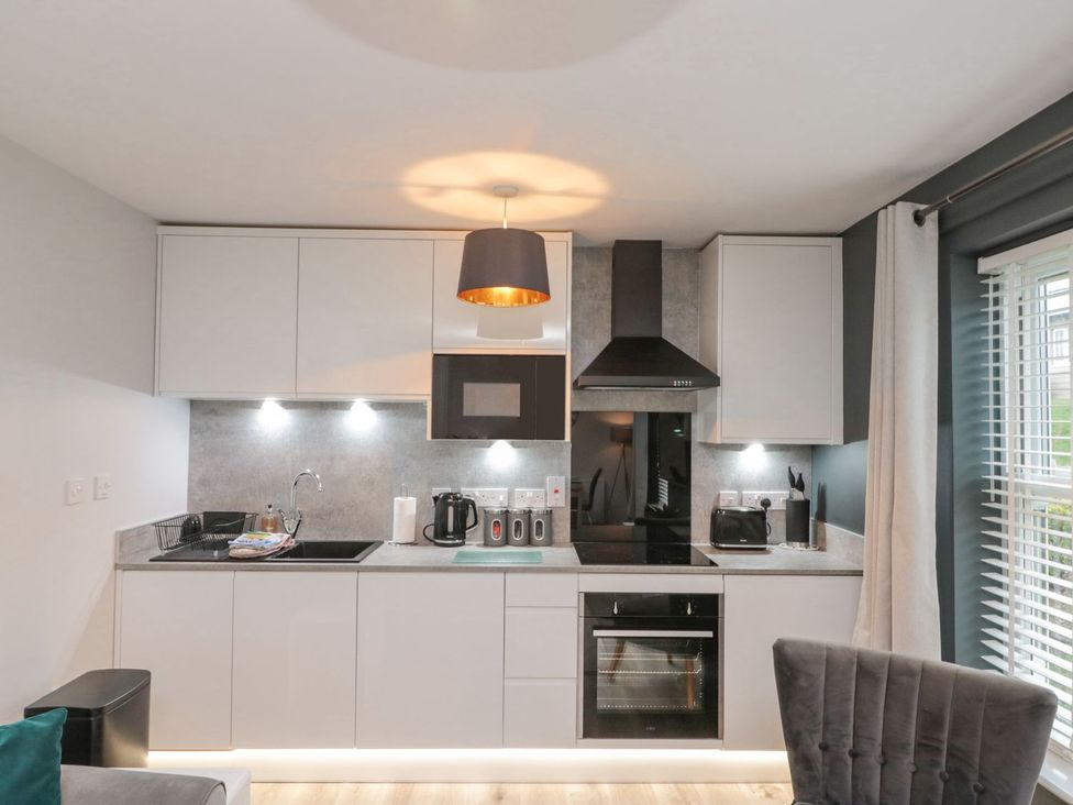 A kitchen with appliances and cabinets at Rosie's Retreat in Filey