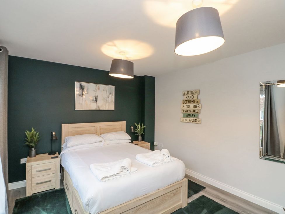 A bedroom with a bed and bedside table at Rosie's Retreat in Filey