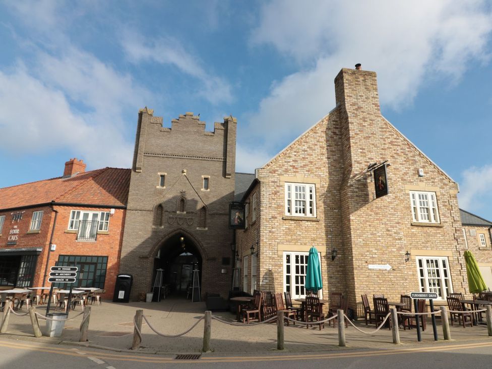 A pub exterior with a gate and outdoor seating at Rosie's Retreat in Filey