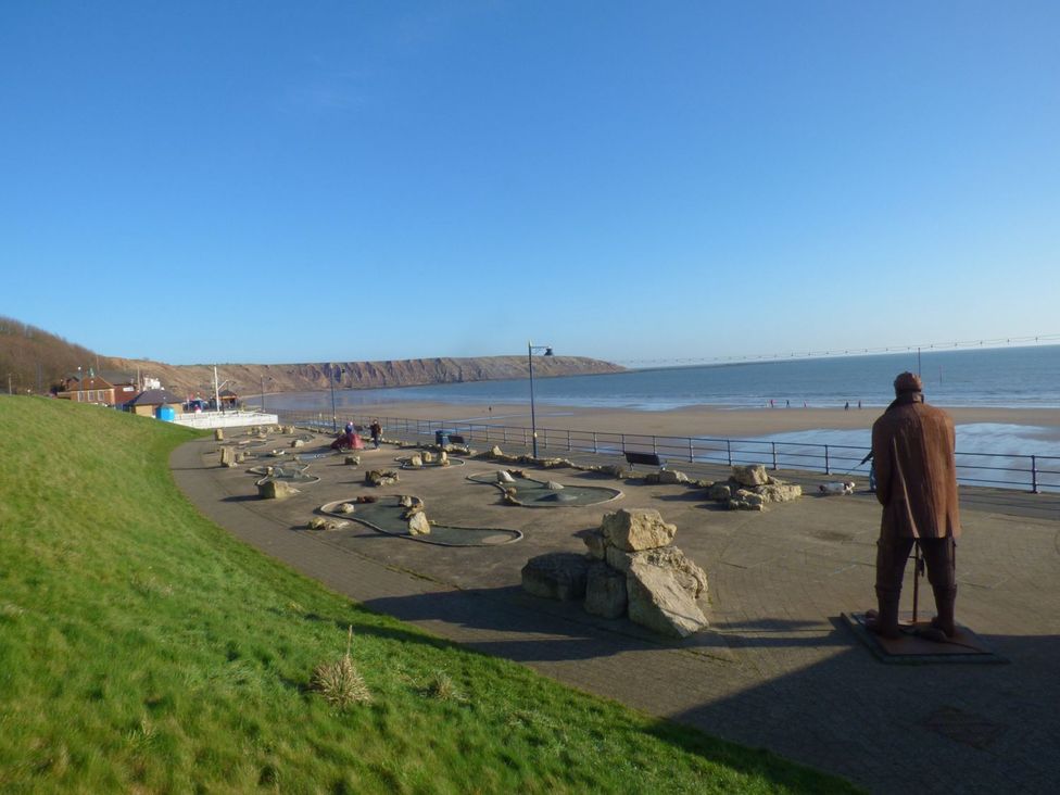 A beach view with cliffs and a promenade at Rosie's Retreat in Filey