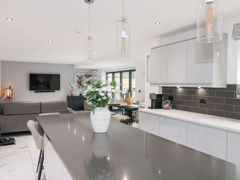 A kitchen with an island, sofa, and dining area at Rockcliffe Grange in Mansfield