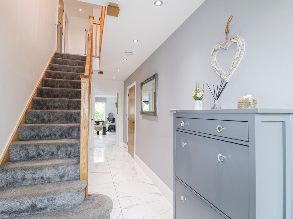 A hallway with a staircase and chest of drawers at Rockcliffe Grange in Mansfield