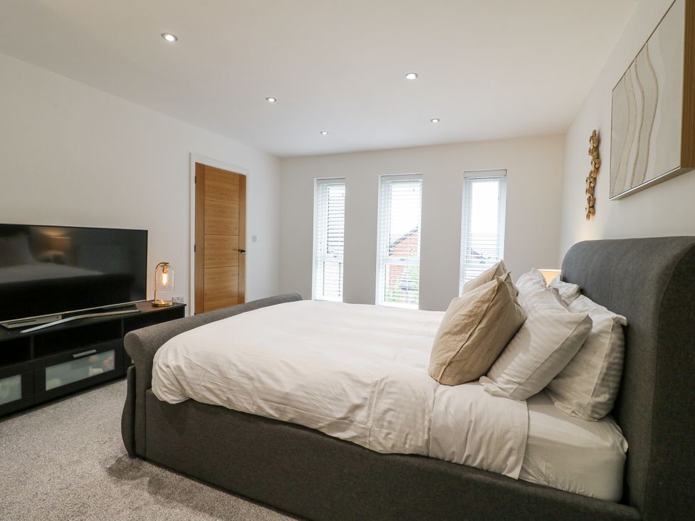 A bedroom with a bed, television and windows at Rockcliffe Grange in Mansfield
