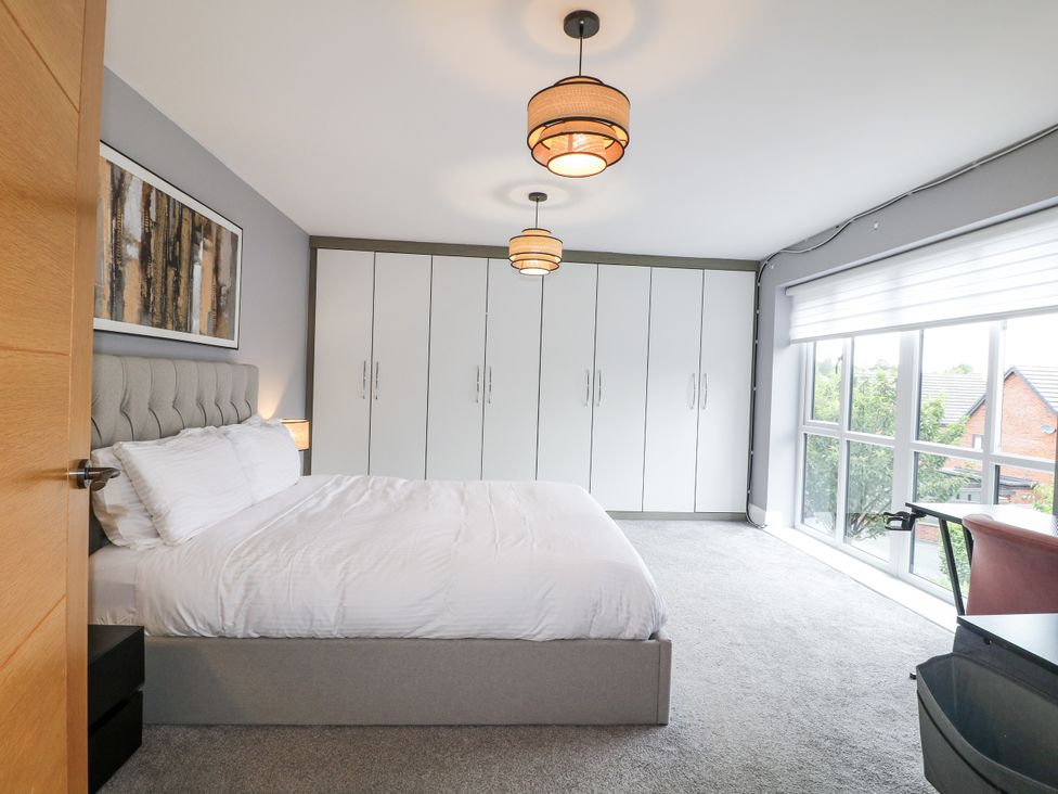A bedroom with a bed and wardrobe at Rockcliffe Grange in Mansfield