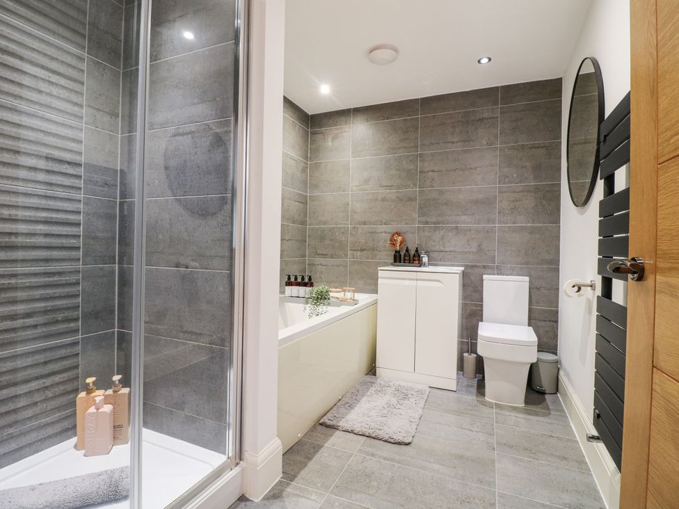 A bathroom with a shower, bathtub, toilet and sink at Rockcliffe Grange in Mansfield