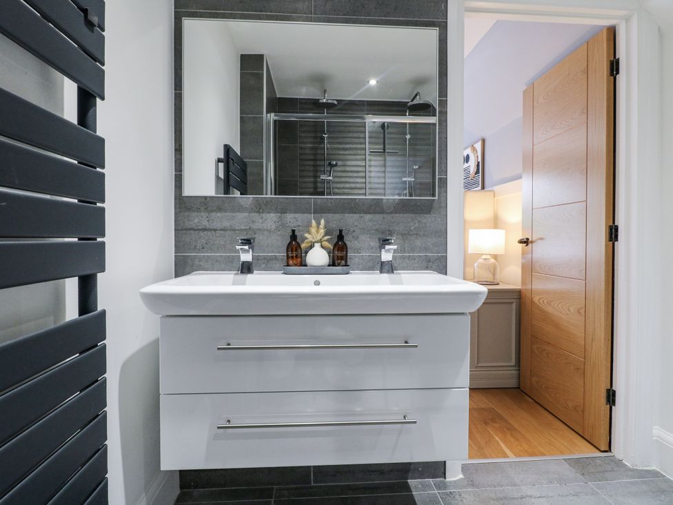 A bathroom with a vanity, mirror, and shower at Rockcliffe Grange in Mansfield