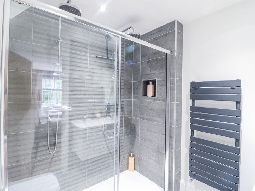 A shower area with glass doors and towel rail at Rockcliffe Grange in Mansfield