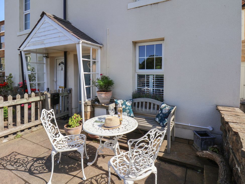 An outdoor seating area with a table and chairs at Woodbine Cottage in Whitby