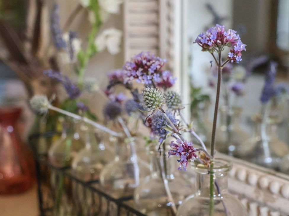 A collection of flowers in vases on a table at Woodbine Cottage in Whitby