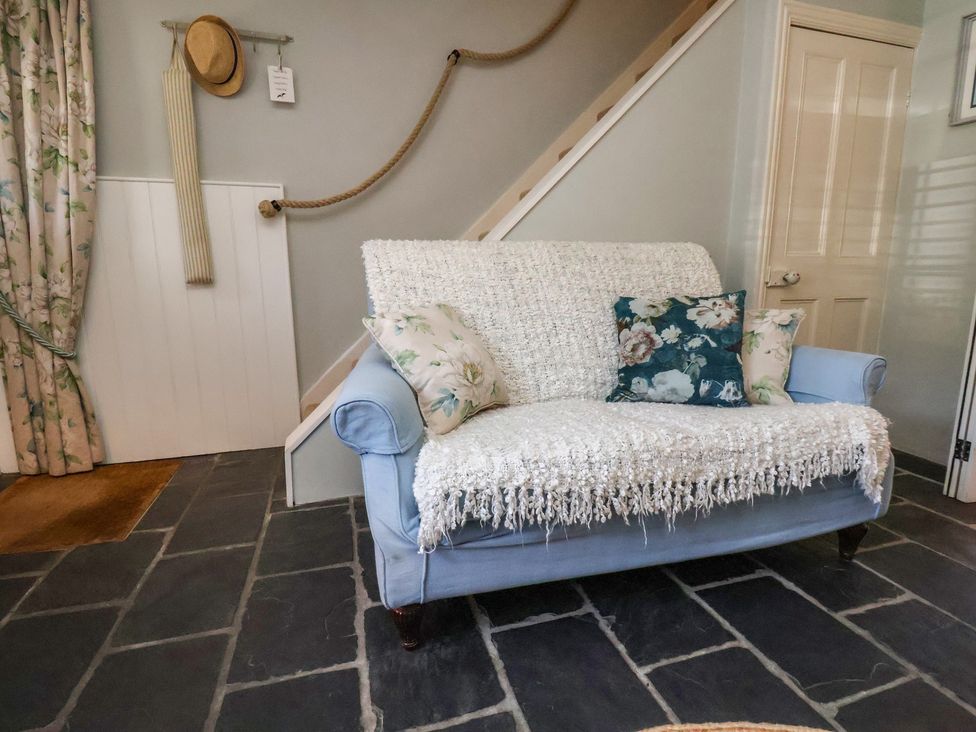 A living room with a sofa and cushions at Woodbine Cottage in Whitby