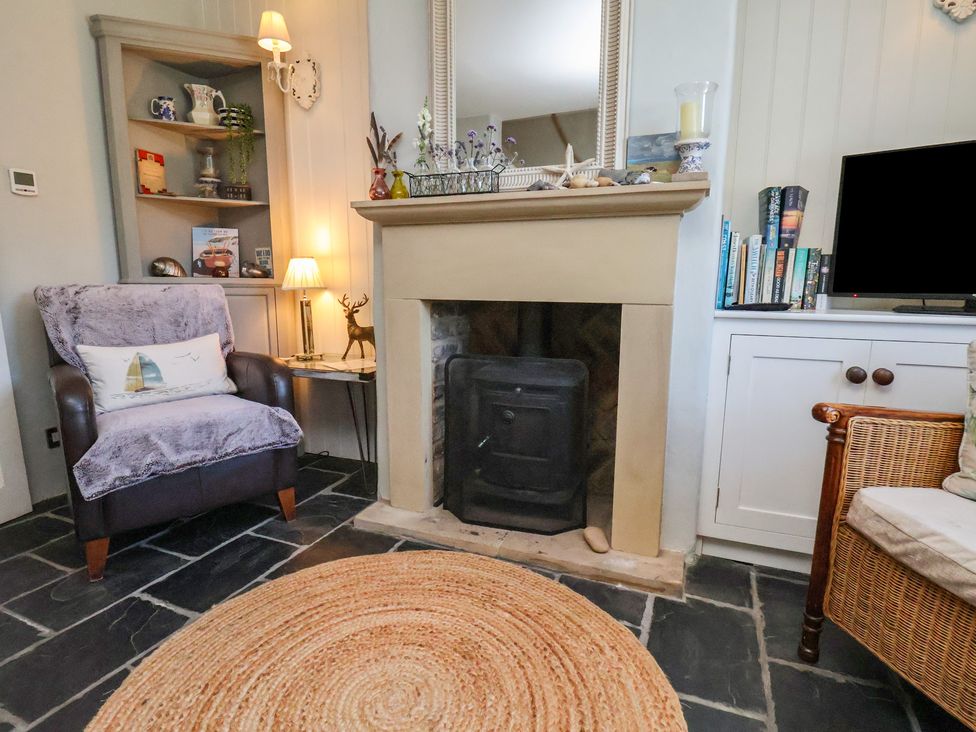 A living room with a fireplace and armchair at Woodbine Cottage in Whitby