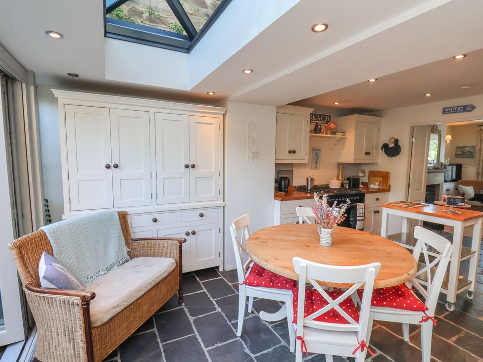 A kitchen with dining table and chairs at Woodbine Cottage in Whitby