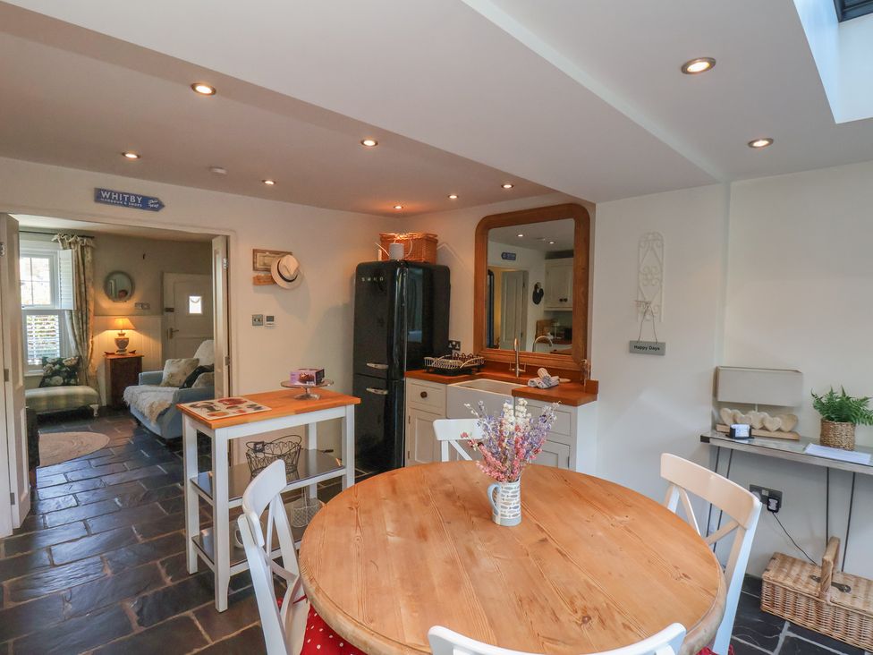 A kitchen with a round table and chairs at Woodbine Cottage in Whitby