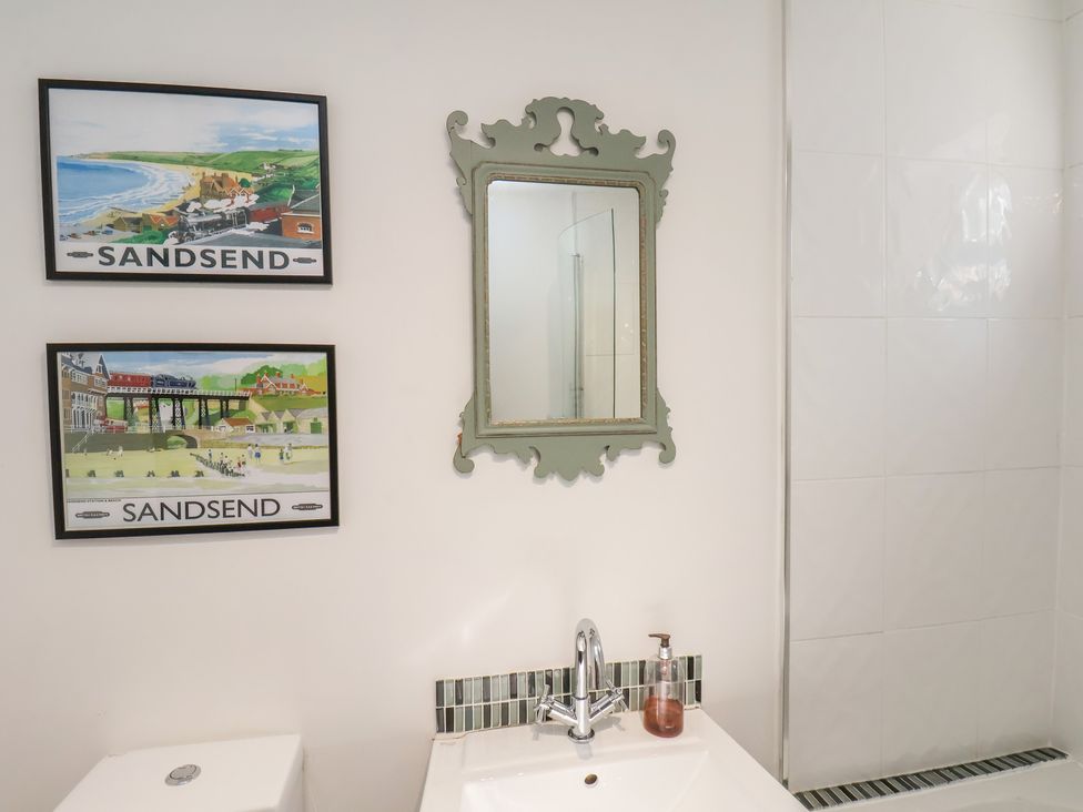 A bathroom with a sink and mirror at Woodbine Cottage in Whitby