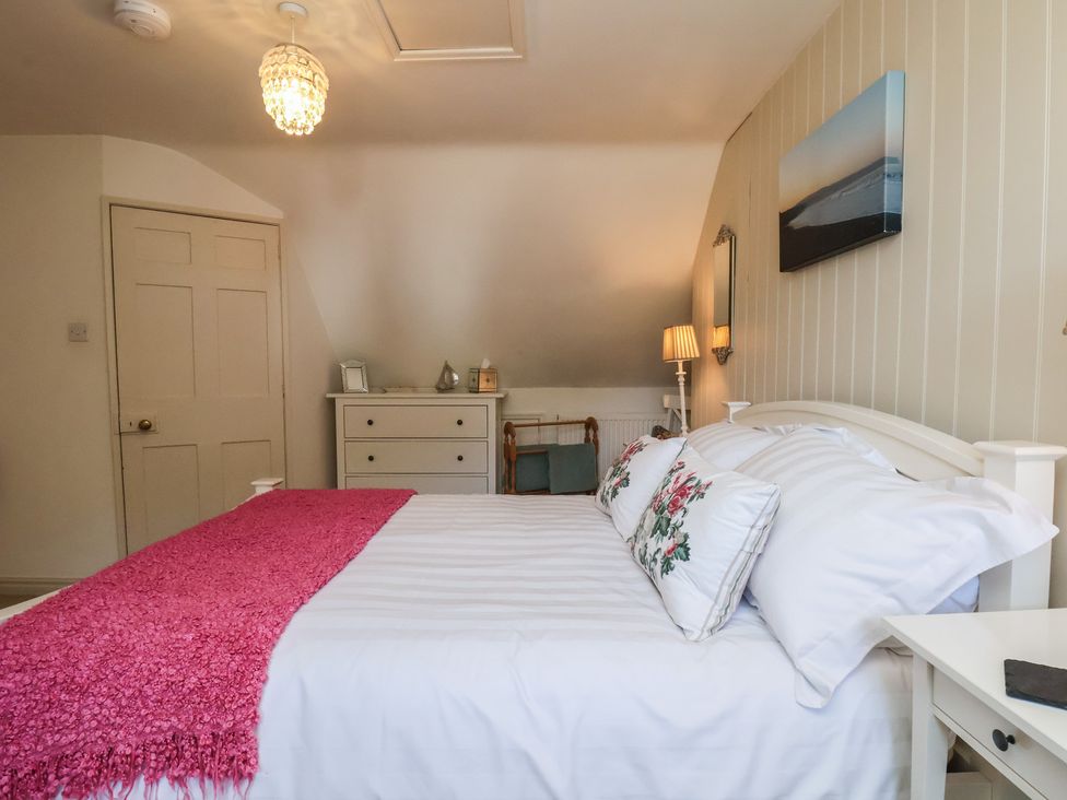 A bedroom with a bed and dresser at Woodbine Cottage in Whitby