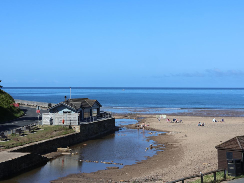 A beach scene with a shack by the water at Woodbine Cottage in Whitby