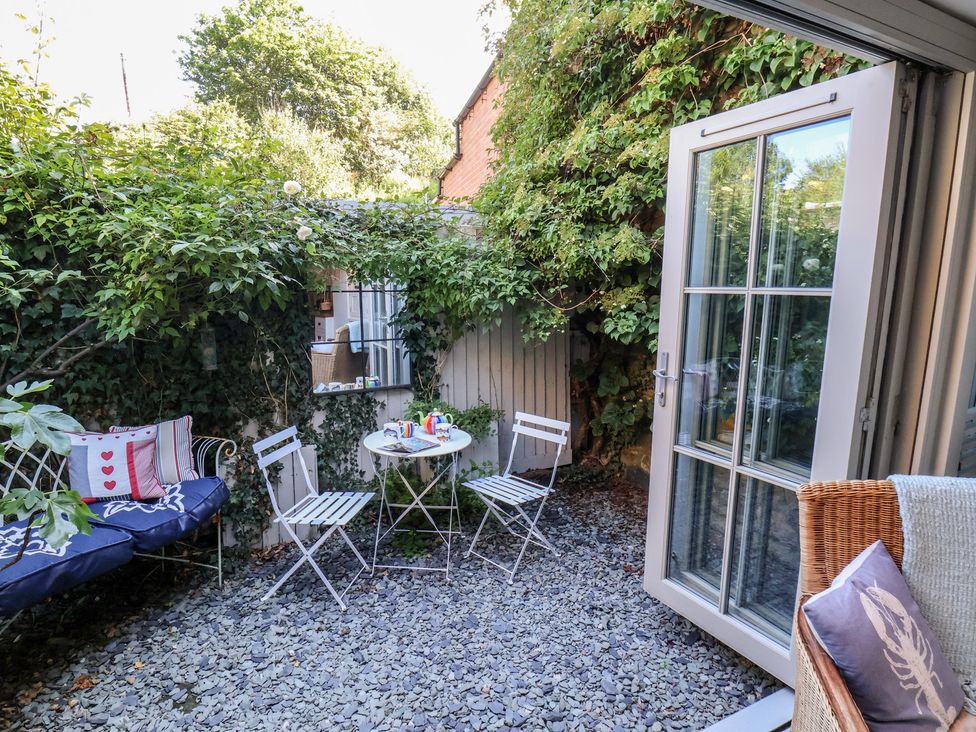 A garden with a table and chairs and a couch at Woodbine Cottage in Whitby
