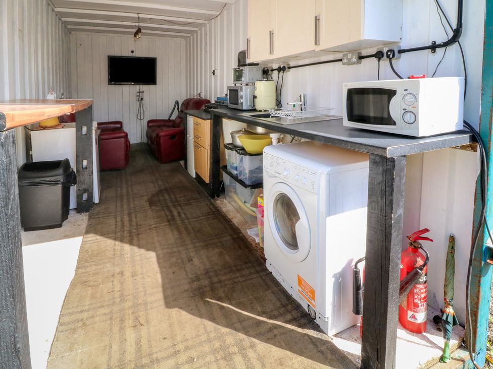 A kitchen with appliances and seating at Bell Tent One