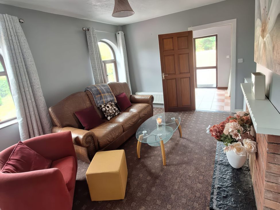 A living room with a sofa and armchair at Lilly's Bungalow Timoleague